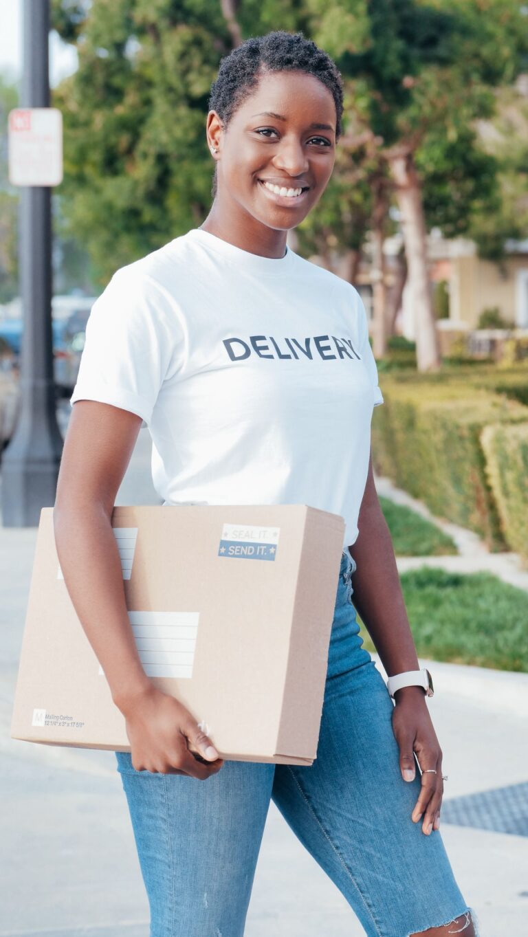A courier carrying a delivery parcel outdoors