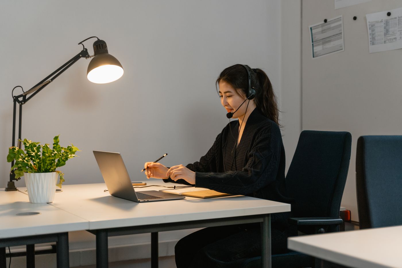 Customer-support professional working with a headset and laptop